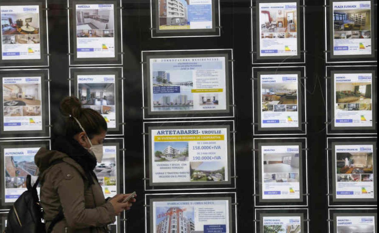 Joven pasando por delante de una inmobiliaria.