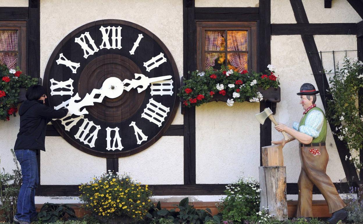 Una mujer cambia la hora en el reloj de cuco más grande del mundo en Schonach (Alemania)