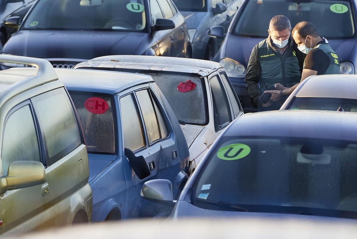 Dos guardias civiles del Servicio de Criminalística junto a los coches de Ricart y Anglés. iván arlandis