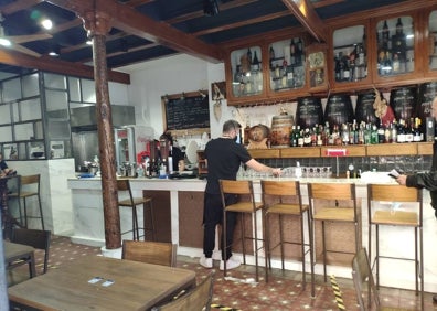 Imagen secundaria 1 - Terraza de la bodega que, en el interior, conserva los barriles a granel, las vigas de madera y algunas piezas recuperadas.