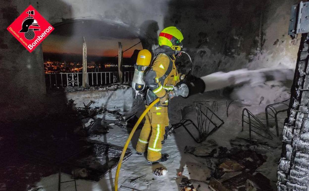 Un bombero acabando de sofocar el fuego en un chalé de Calp.  