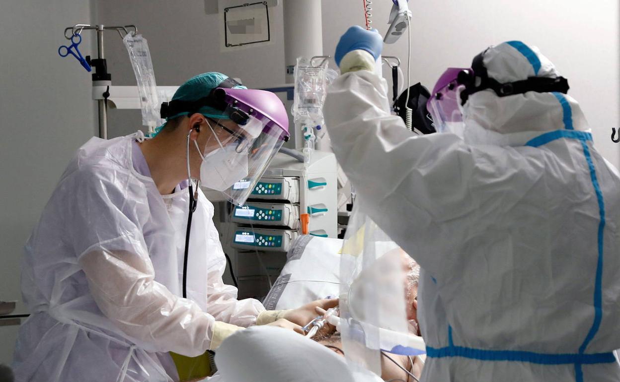 Sanitarios atendiendo a un paciente en la UCI de La Fe. 