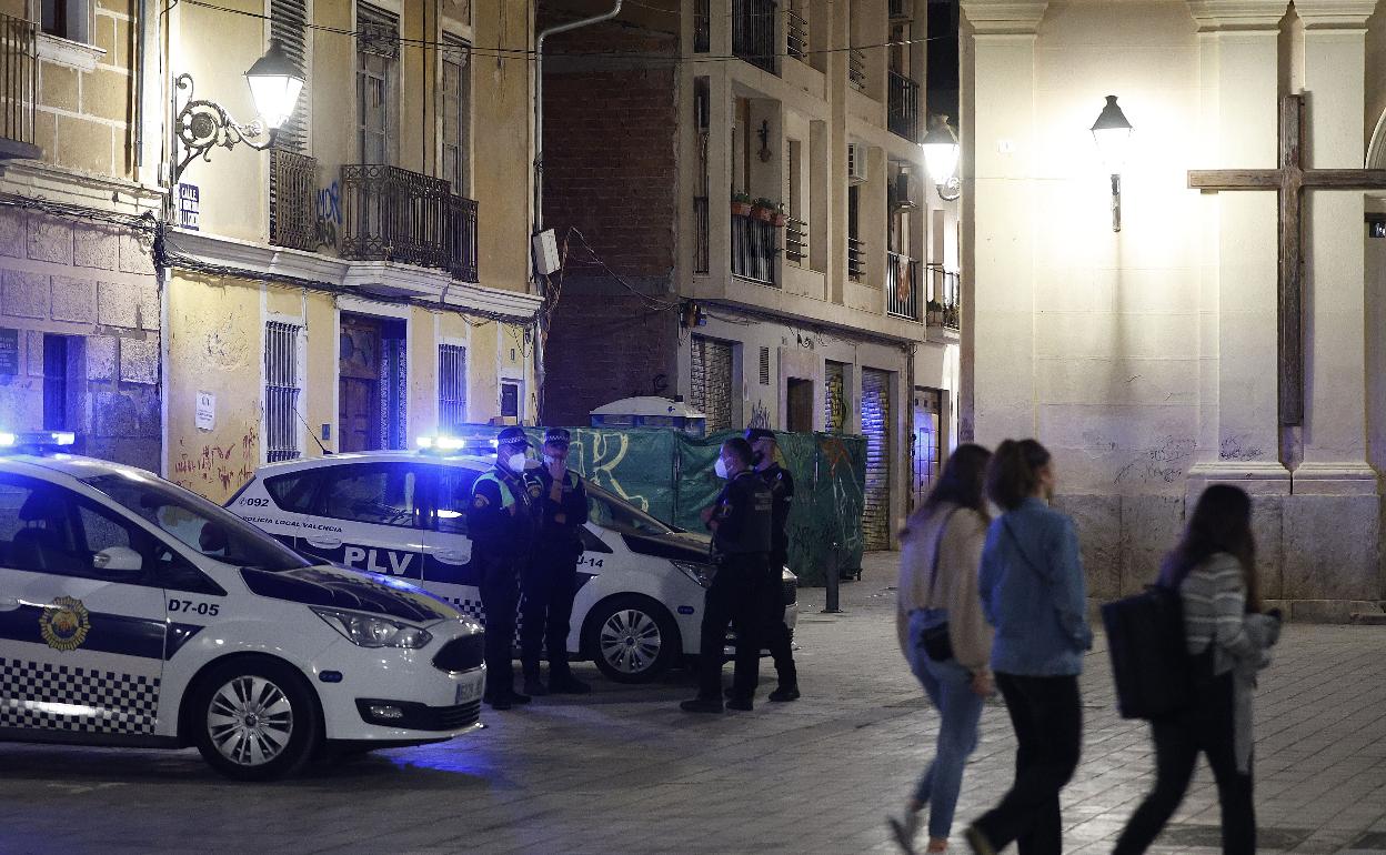 Agentes de la Policía Local vigilan de noche una calle de Valencia. 