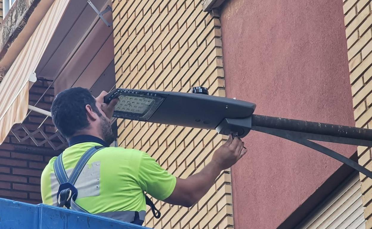 Un trabajador repara una farola. 