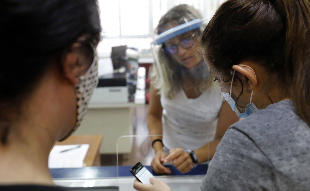 Dos mujeres resuelven dudas en un colegio durante la primera admisión telemática, en 2020. 