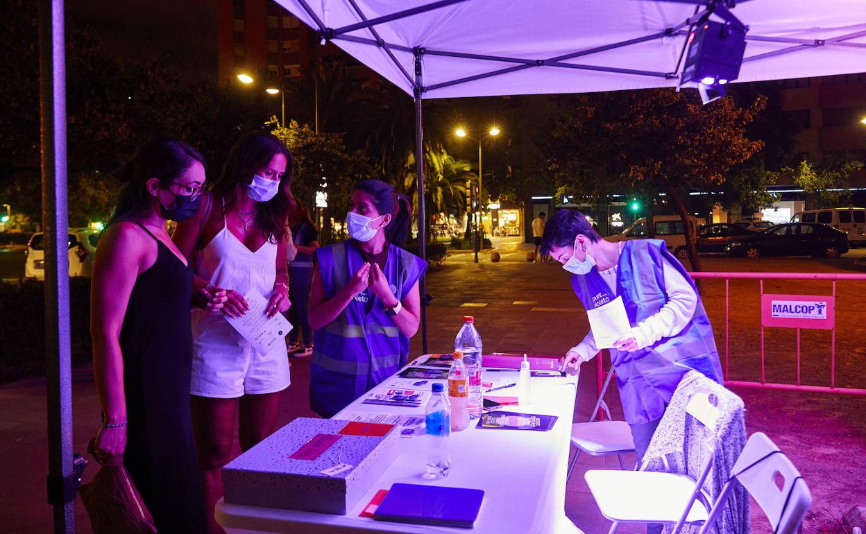 Unas jóvenes se interesan por un punto violeta en Honduras.