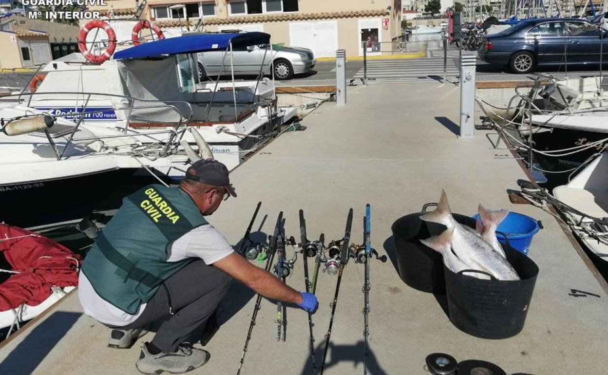 Un agente muestra el material incautado en esta embarcación de recreo. 