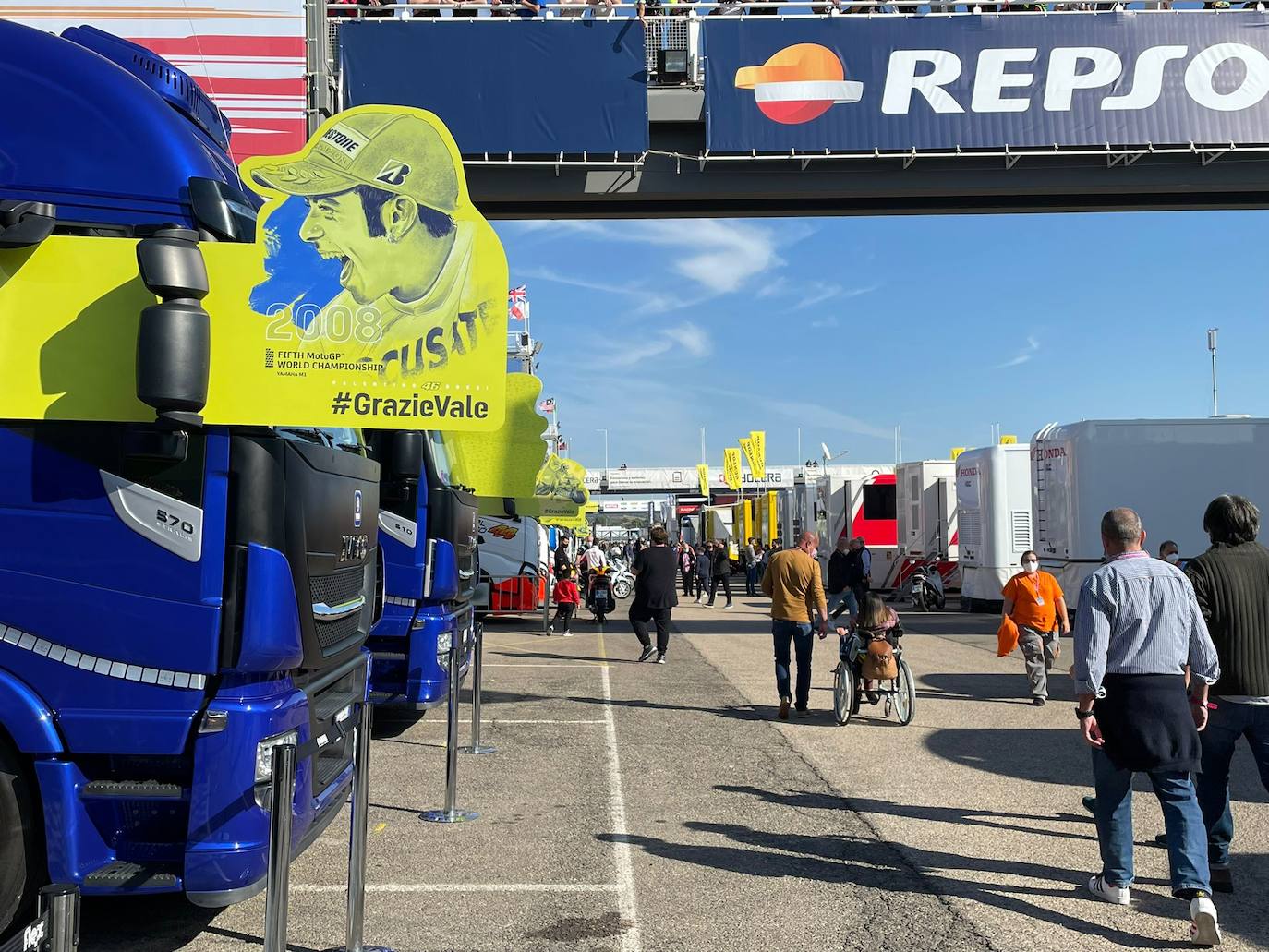 El paddock se ha teñido de amarillo este fin de semana. Como las gradas, que el sábado ya han expresado una muestra de intención de lo que será la carrera de este domingo. No es para nada exagerado afirmar que el 70% de los aficionados lucían merchandising de Valentino Rossi. Entre las muestras de homenaje que se le han dedicado por el momento, destaca la exposición de las nueve motos con las que ha sido campeón del mundo. Al lado está la 'Piazza Valentino Rossi', rotulada con una placa que simula ser de mármol y donde hay unos paneles amarilos que expresan los principales hitos del mito transalpino a lo largo de su carera. Más allá de esto, la mayoría de los camiones de los equipos tienen un panel, del mismo diseño, como muestra de gratitud al piloto por haber potenciado el Mundial de MotoGP durante sus más de 25 años de carrera. El propio piloto, en su mono, luce en la parte posterior este fin de semana un escueto pero representativo: 'Grazie'.