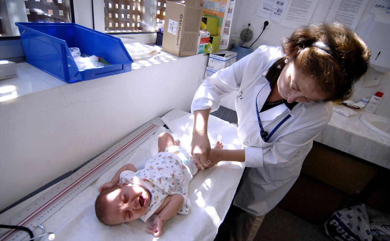 Personal sanitario administra una vacuna a un bebé.