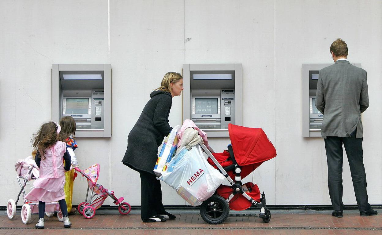 Una familia usa un cajero automático. 