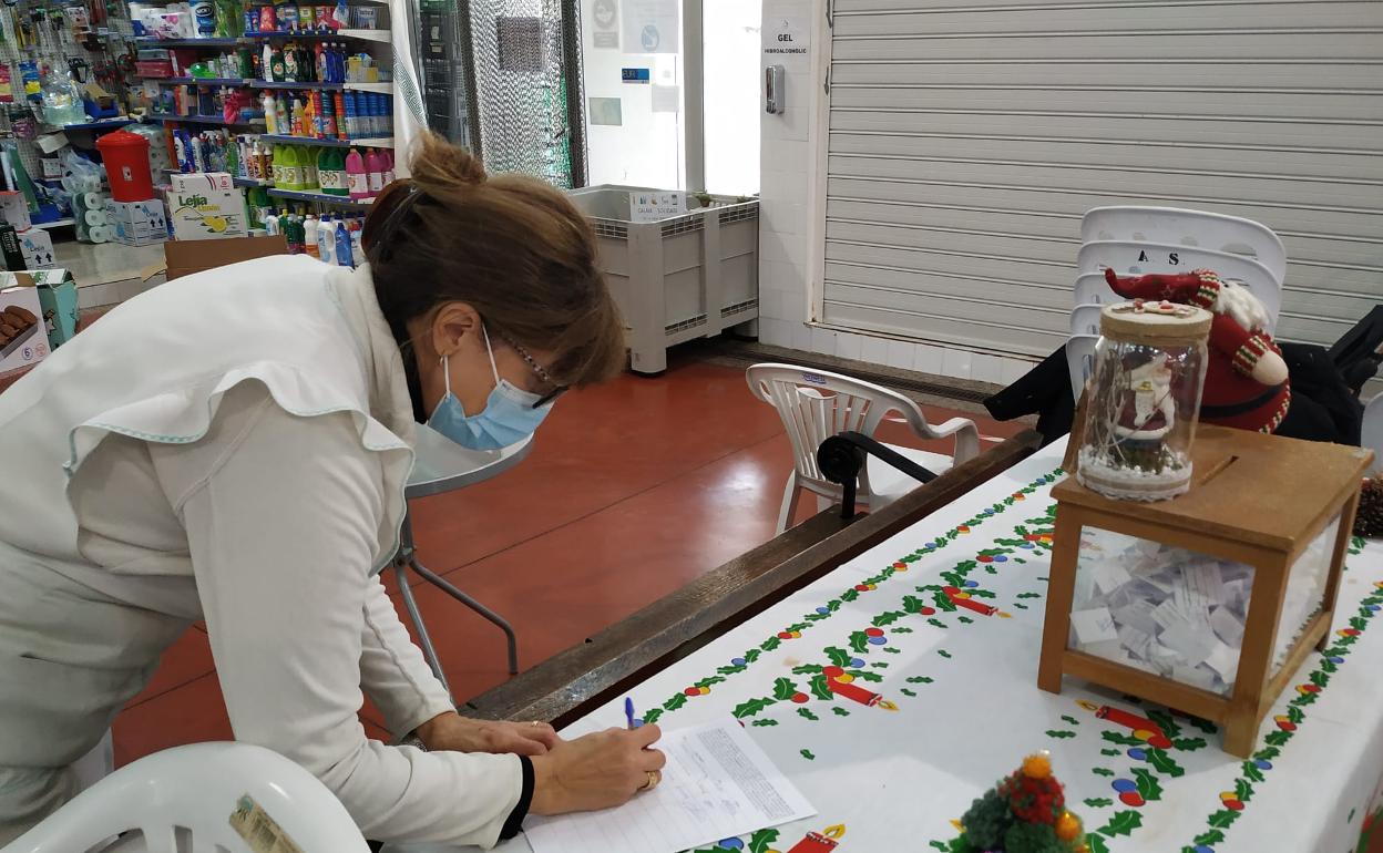 Una vecina firma en el Mercado de Simat. 