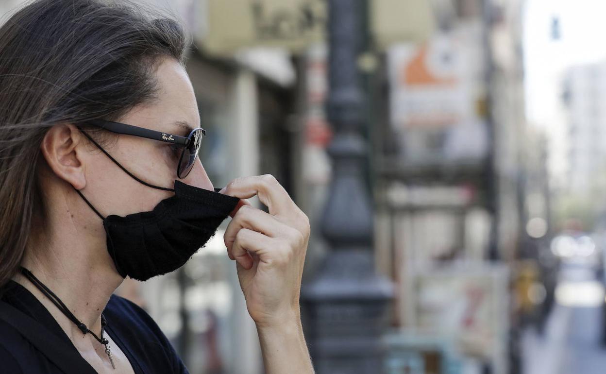 Una persona se acomoda la mascarilla.