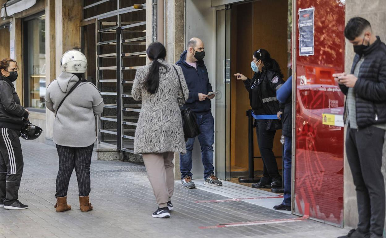 Personas esperando en la entrada de una oficina de Labora en Valencia. 