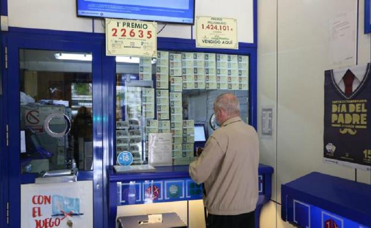 Un hombre sella sus boletos en una administración de lotería.