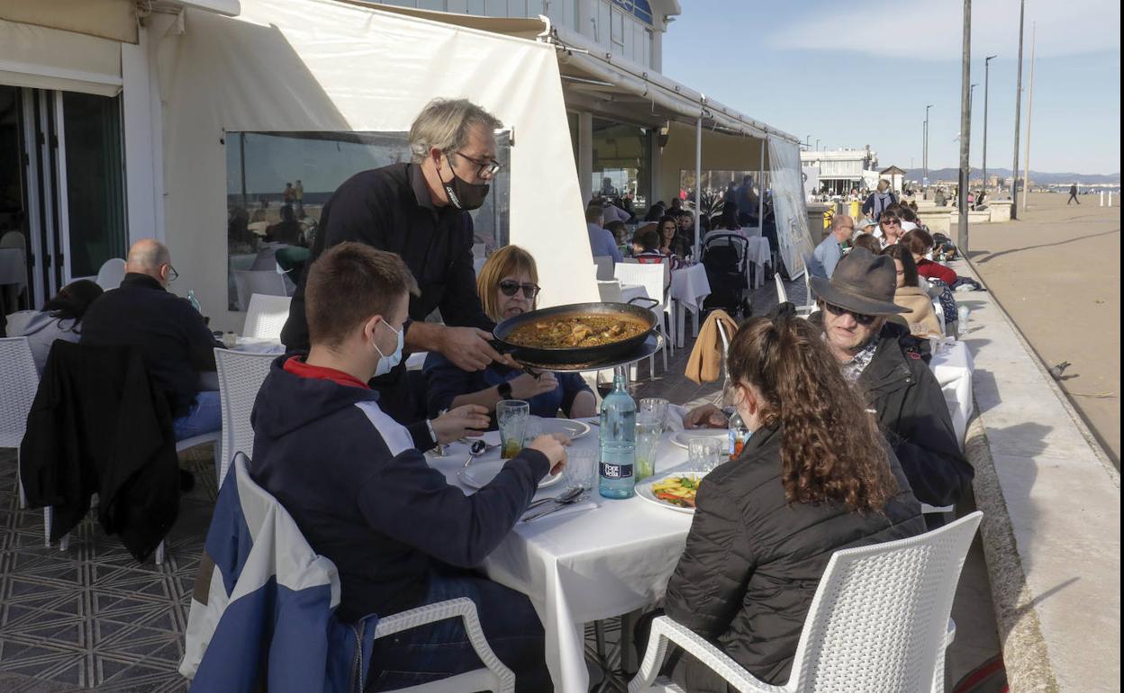 Personas disfrutan de un arroz en una terraza