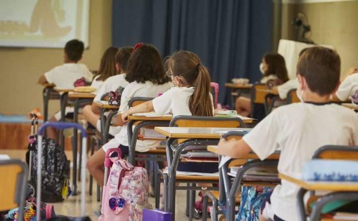 Niños con mascarilla en un colegio, en una foto de arhivo.