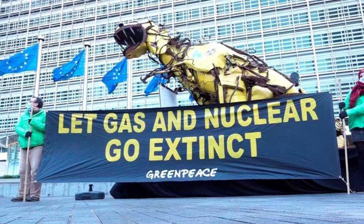 Activistas de Greenpeace instalan un dinosaurio gigante de chatarra frente a la sede de la Comisión Europea, en señal de protesta contra la posible inclusión del gas natural y de la tecnología nuclear en la lista de energías verdes.