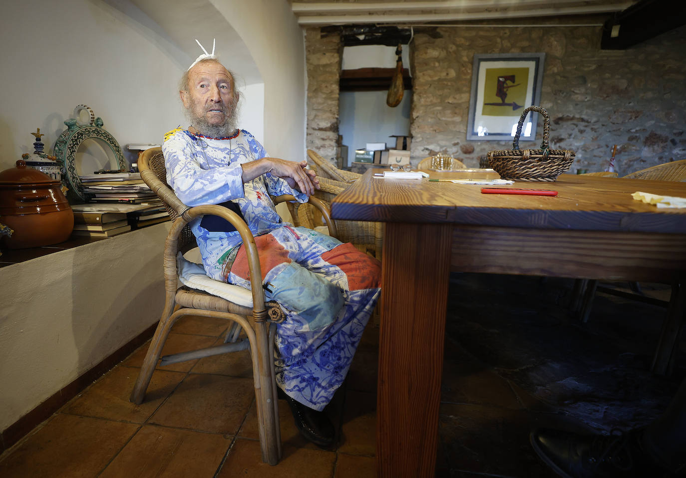 El artista, sentado ante la enorme mesa de comedor, donde recibe a amigos continuamente.