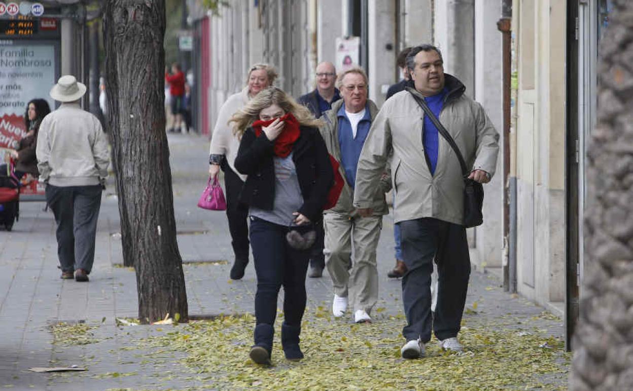 Personas con abrigo y bufandas en Valencia.