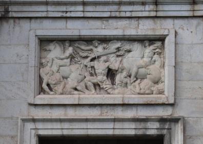 Imagen secundaria 1 - Grabados de la Porta de la Mar en su fachada hacia la calle Navarro Reverter, que representan 'La Abnegación' y 'El Valor', junto a la cruz central del monumento.