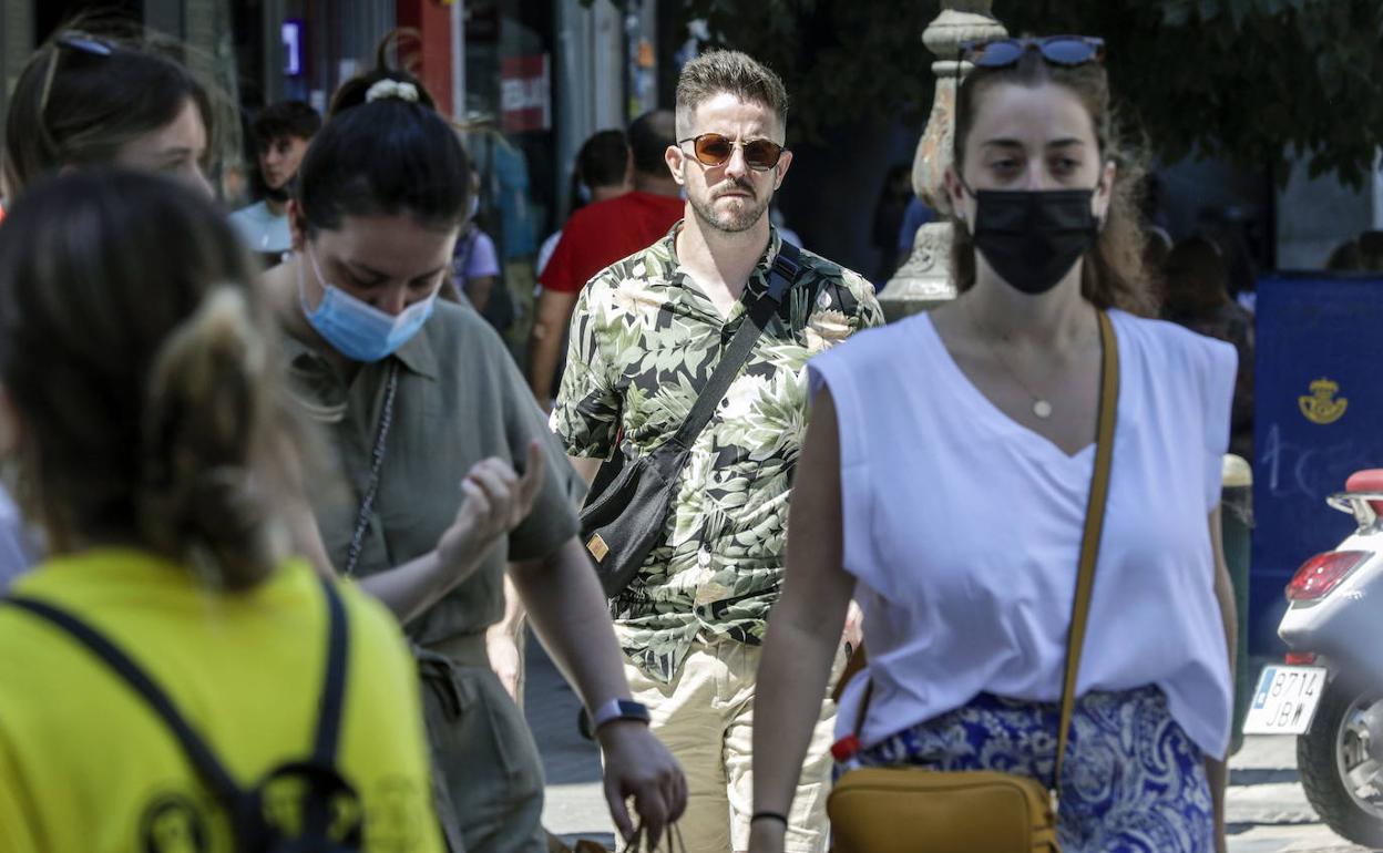 Varias personas con mascarilla por la calle. 