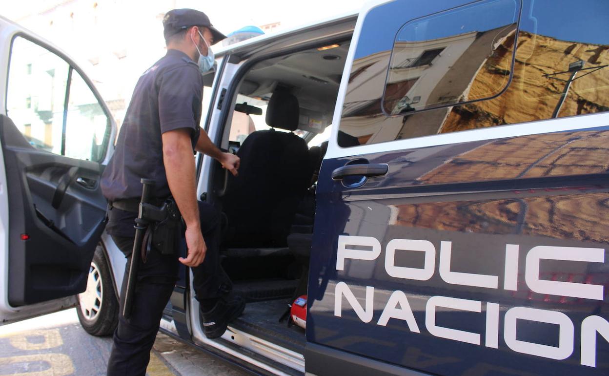 Un agente de la Policía Nacional abre la puerta lateral de un furgón policial, en una imagen de aqrchivo. 