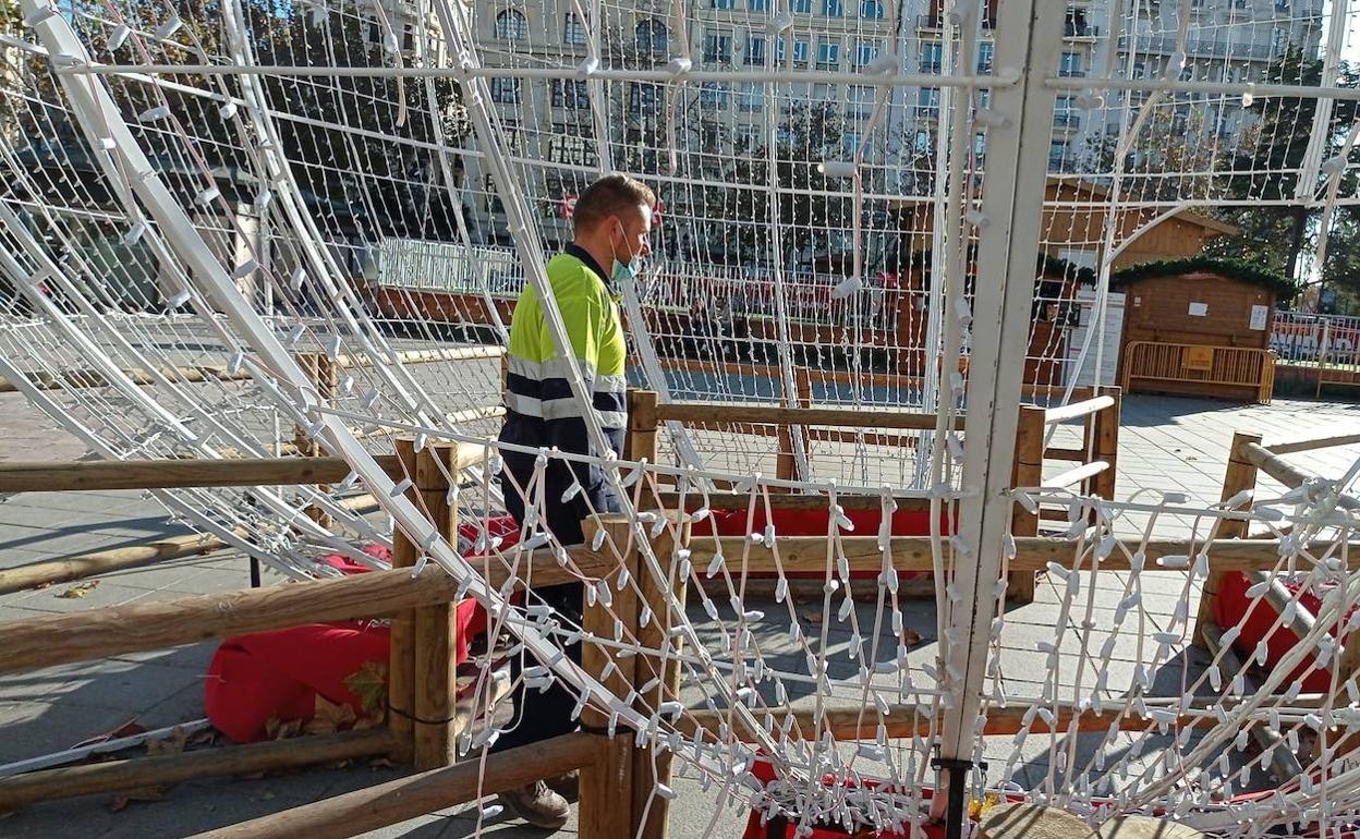 Un operario pasa este lunes por el interior de una de las bolas navideñas dañadas. 