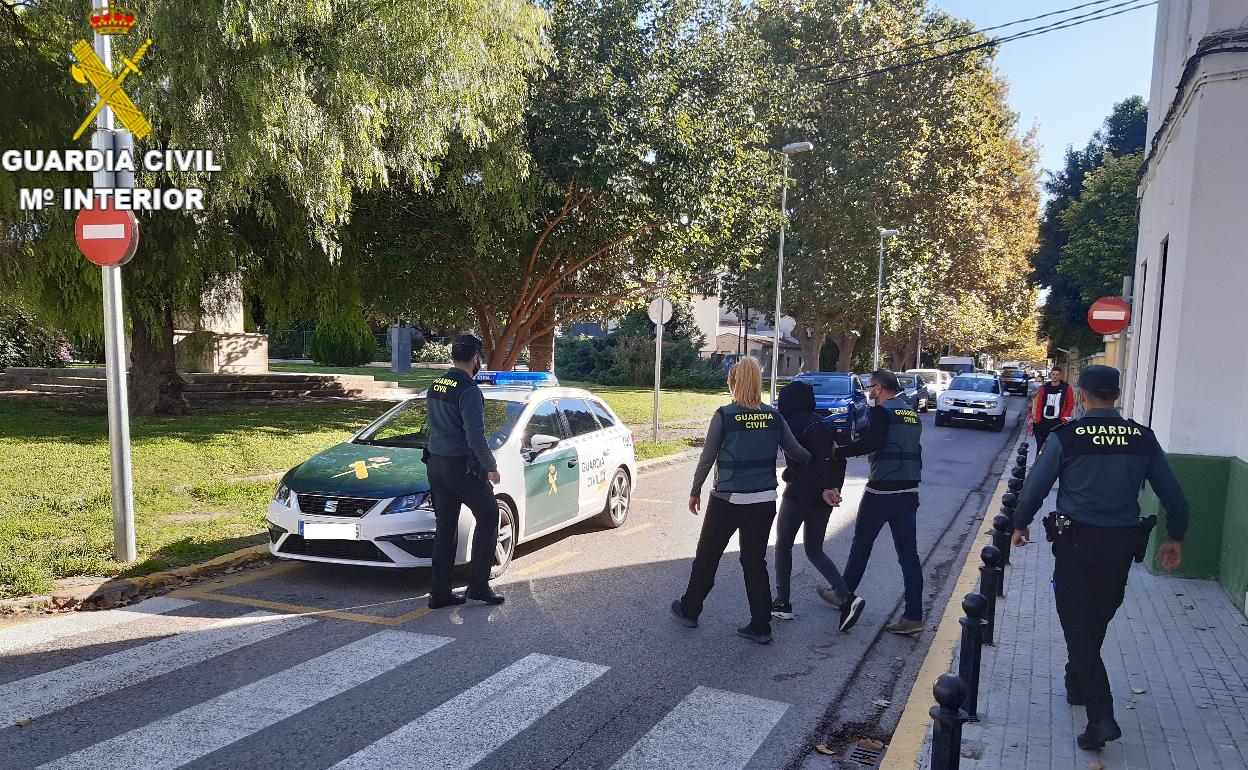 Una persona detenida, custodiada por varios agentes de la Guardia Civil. 