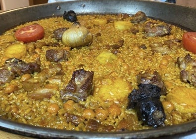 Imagen secundaria 1 - Arriba, terraza del restaurante. Abajo, arroz al horno en paella y almejas de carril a la marinera.