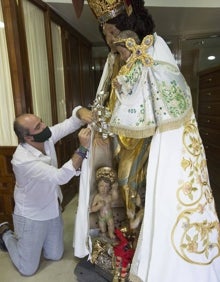 Imagen secundaria 2 - Detalle de las flores del manto; la cartela con la inscripción interior; Francisco Perales, en la prueba del manto sobre la Peregrina.