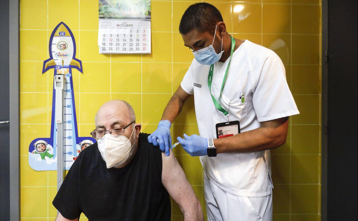 Personal sanitario administra una dosis de la vacuna a un paciente.