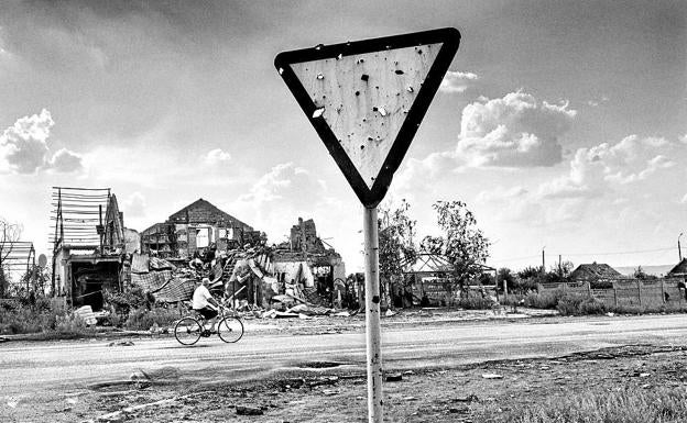 Un lugareño pasa junto a una casa destruida en el pueblo de Semyonovka, Ucrania oriental q