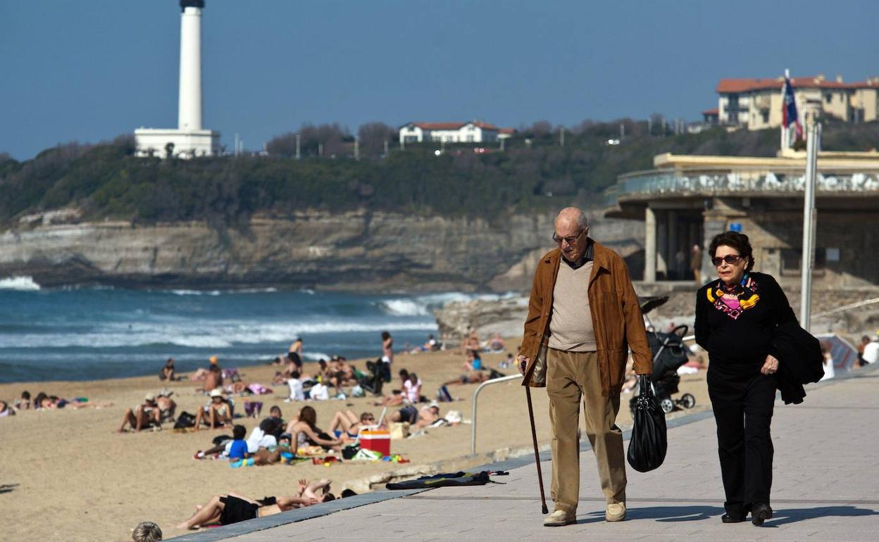 Dos jubilados paseando por la playa. 