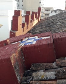 Imagen secundaria 2 - Parte superior del edificio donde se aprecia la falta de una greca, que se desplomó hacía adentro. En las imágenes inferiores, el tramo cortado de la calle Mayor de Gandia y greca derrumbada. 