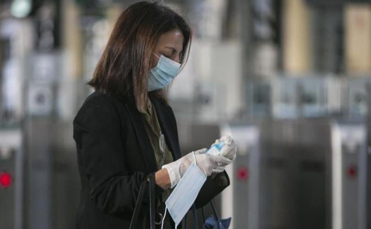 Una mujer con mascarilla en el metro.