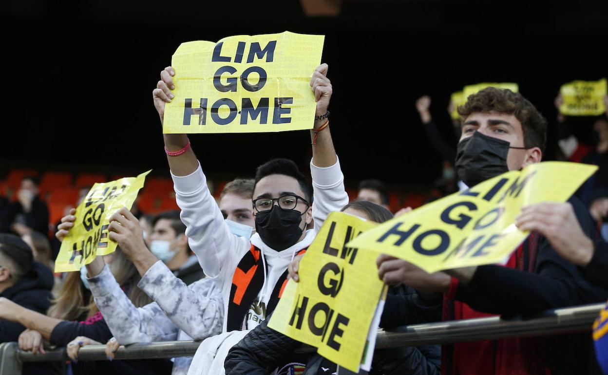 Aficionados del Valencia, con una pancarta de Lim Go Home en Mestalla. 