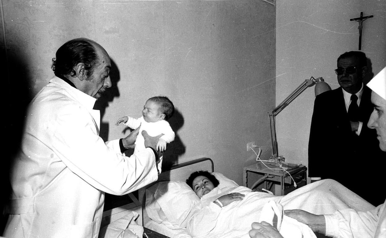 El Dr. Miguel Torregrosa atiende a una mujer tras dar a luz en febrero de 1972.