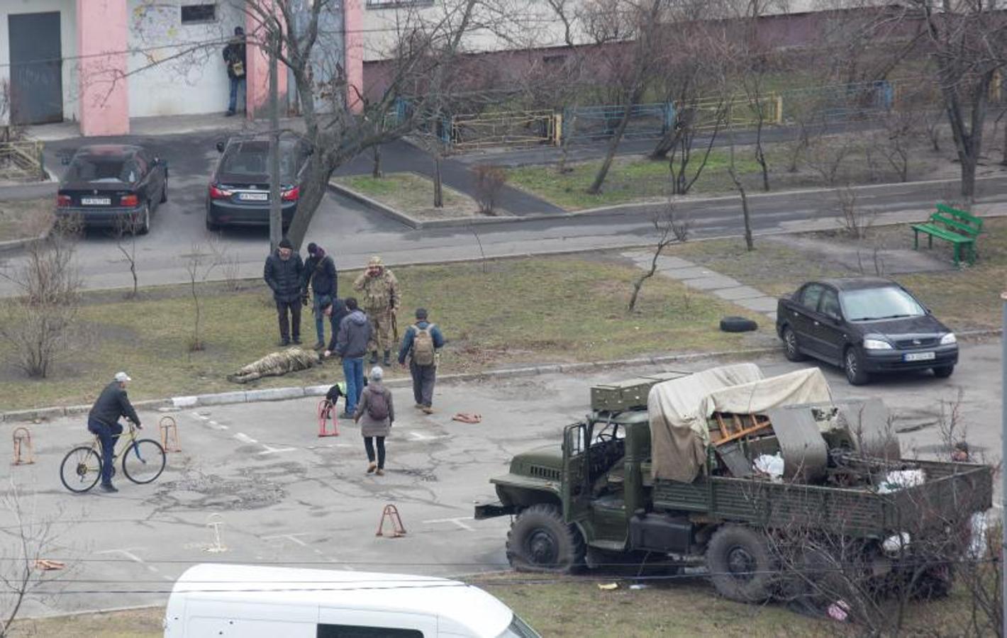 Un grupo de personas rodea a un militar.