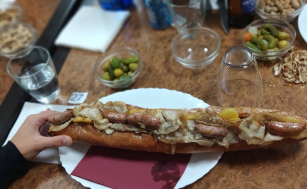 Imagen principal - Arriba, bocadillo entero de lomo, longanizas, patata y cebolla caramelizada. Abajo, medio de chipirones y a la derecha, barra libre de cacaus y olivas. 