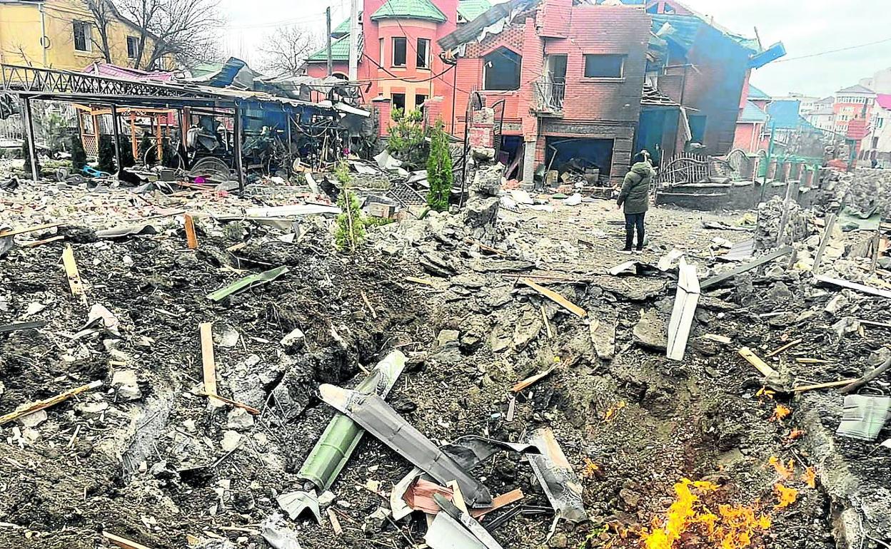 Entre cascotes y ruinas, un ciudadano ucraniano observa el efecto de los bombardeos rusos en Kiev. 