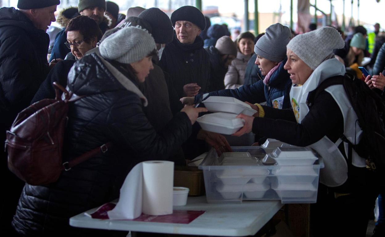 Reparto de comida a los refugiados antes de emprender el viaje a Valencia. 
