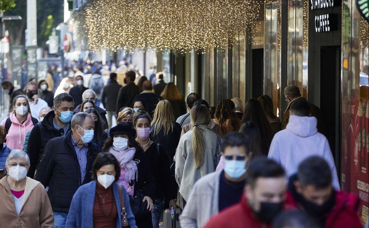 Ciudadanos con mascarilla pasean por la calle Colón de Valencia la pasada Navidad. 