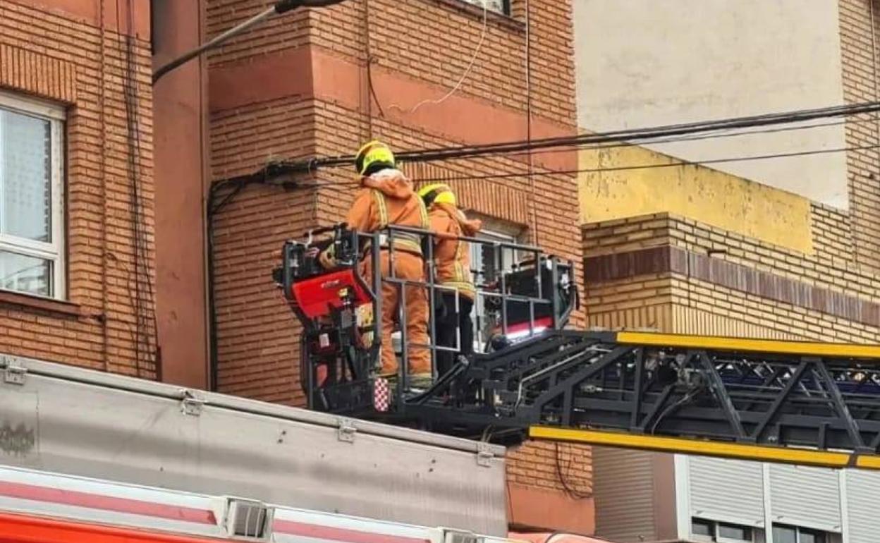 Los bomberos rescatan a la familia por la ventana. 