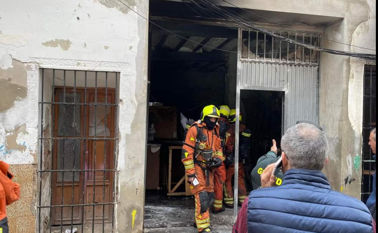 Bomberos en la pequeña nave donde han ardido ninots de dos fallas de Alberic. 