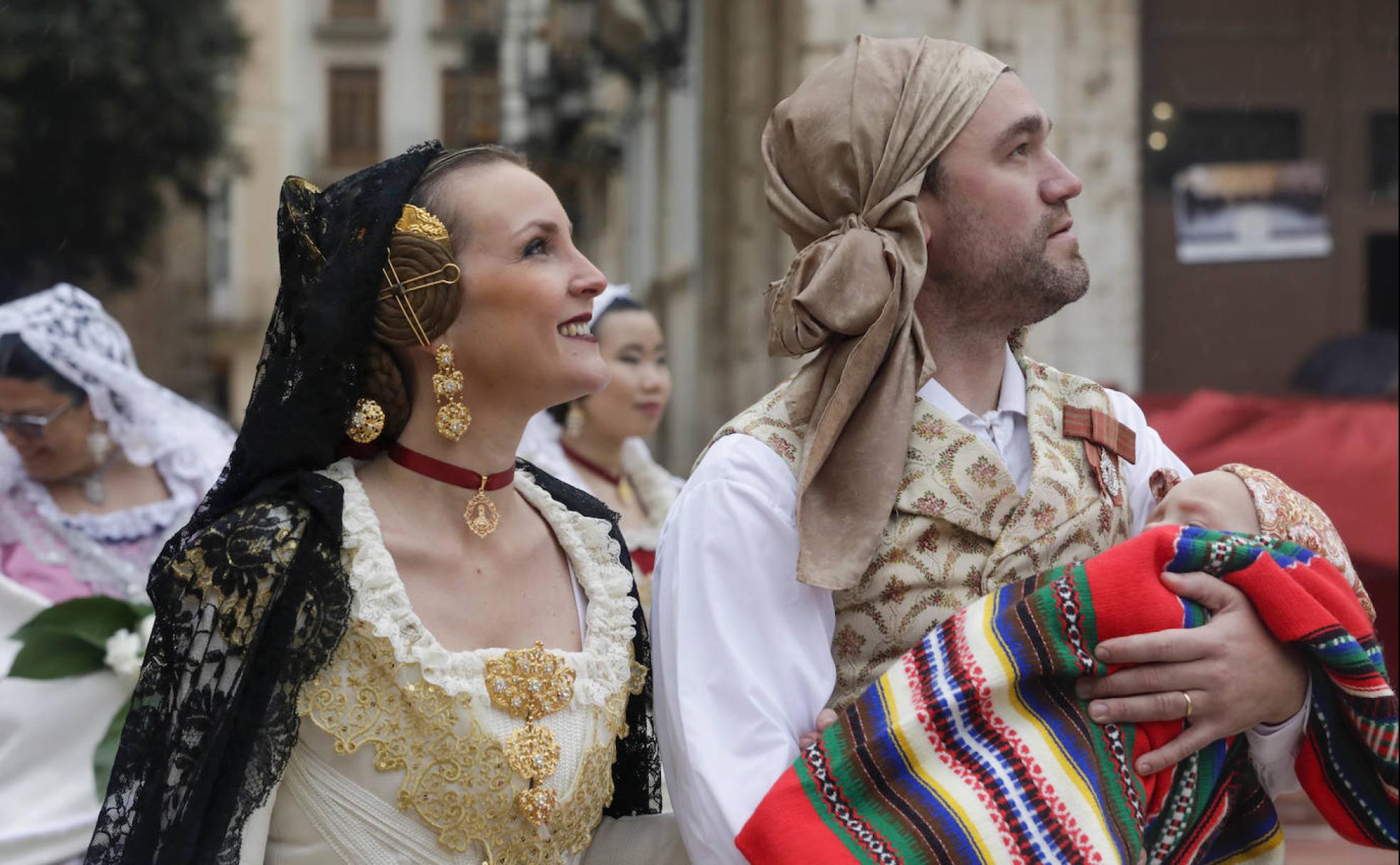 Una pareja de falleros pasa ante la Virgen. 