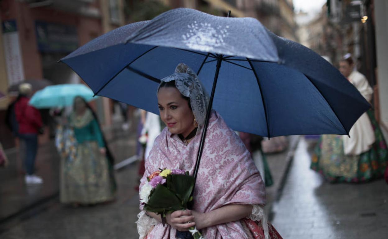 Fallera con paraguas durante la Ofrenda.