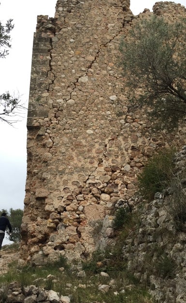 Imagen principal - En la parte superior, las grietas que causó el terremoto del XVI; abajo el espacio de la puerta de entrada donde han desaparecido los sillares y una esquina de la torre. 