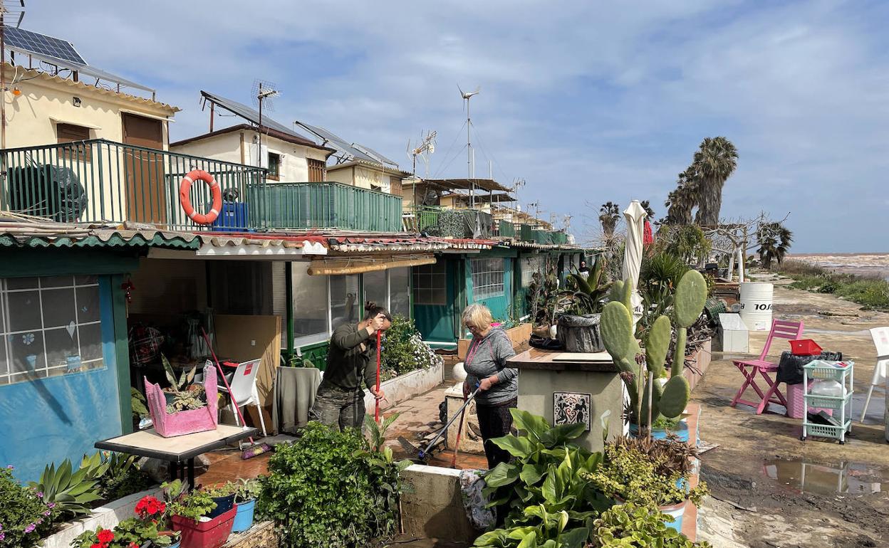 Una familia saca el barro de su vivienda en la zona inundada. 