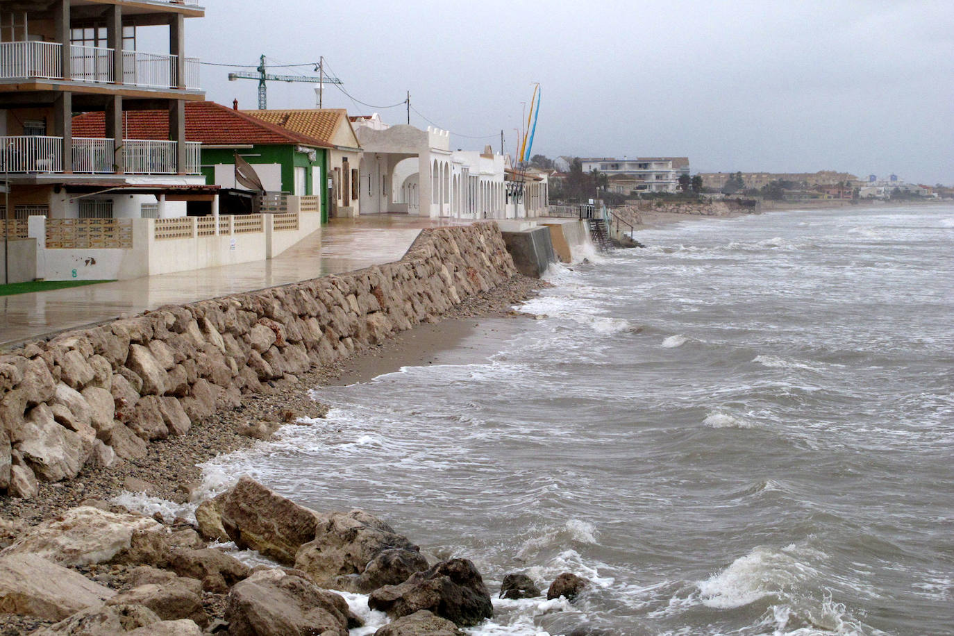 Playa de Les Deveses, con el mar llegando al muro de contención y casi sin tramo de arena por el oleaje y por elevarse el nivel del agua.