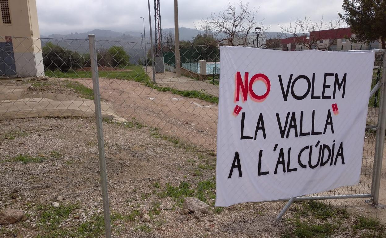 Una pancarta atestigua la oposición de algunos vecinos a la instalación de la valla. 